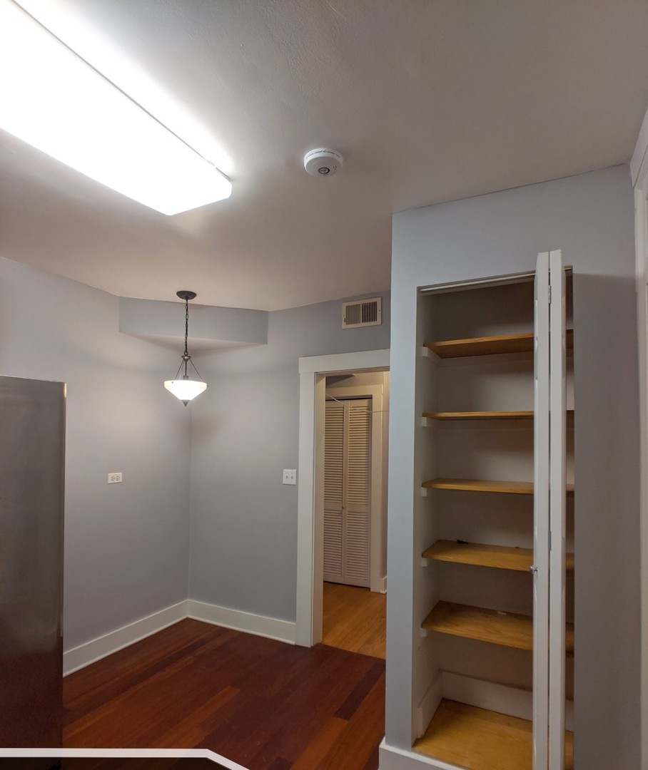 5027 North Harding Avenue, Unit 2W Chicago, IL 60625 - Photo 12 of 20 a view of empty room with wooden floor and fan
