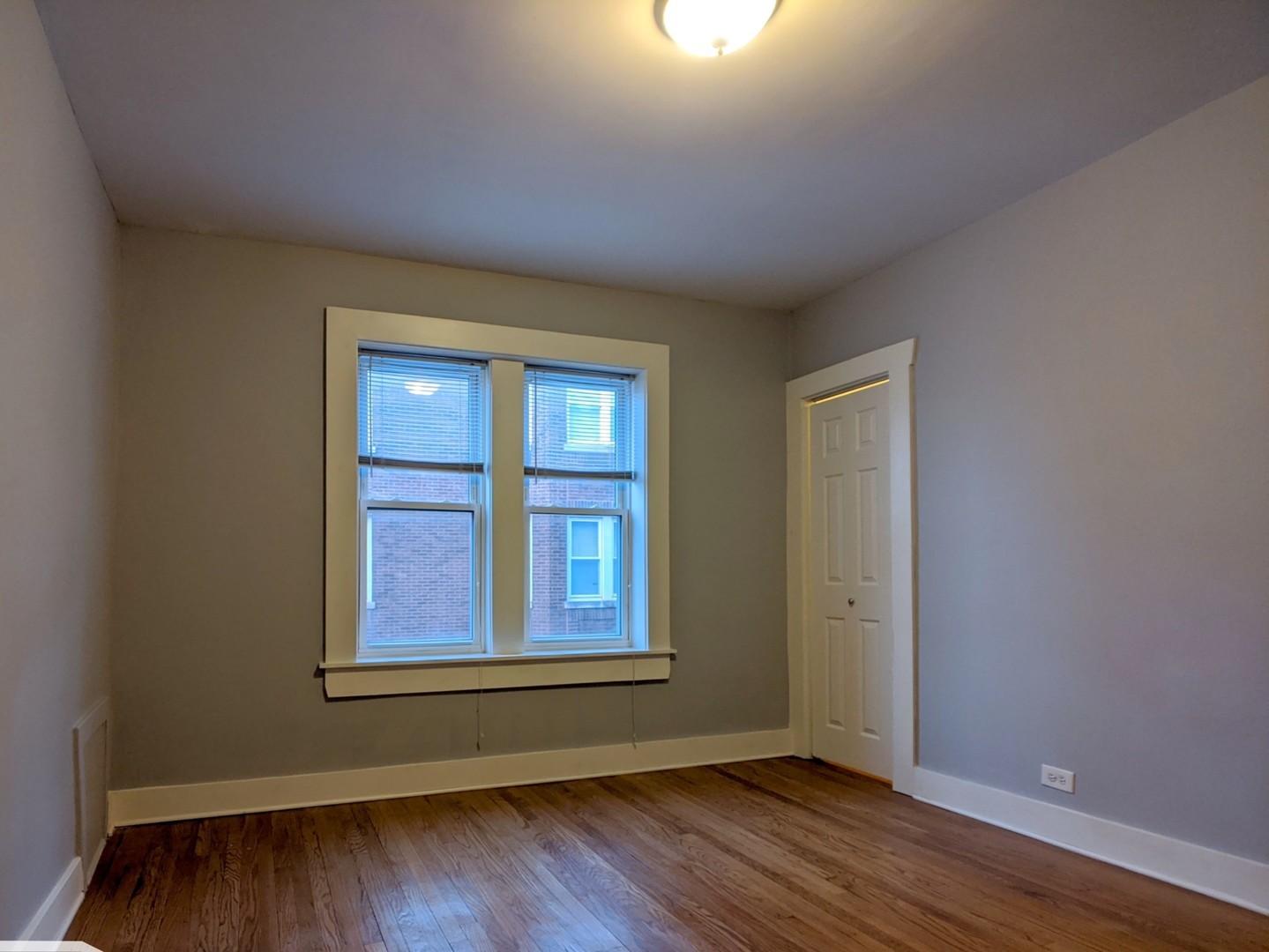 5027 North Harding Avenue, Unit 2W Chicago, IL 60625 - Photo 14 of 20 an empty room with wooden floor and windows