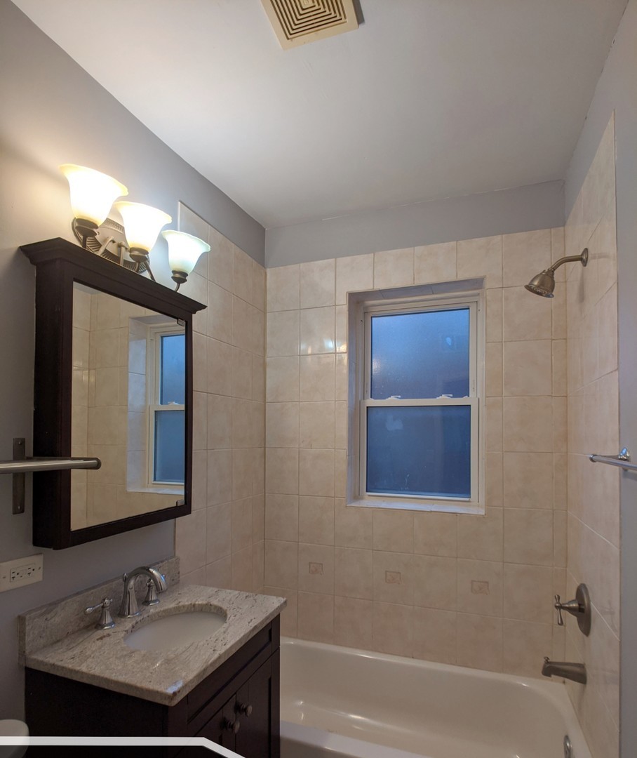 5027 North Harding Avenue, Unit 2W Chicago, IL 60625 - Photo 17 of 20 a bathroom with a sink and a mirror