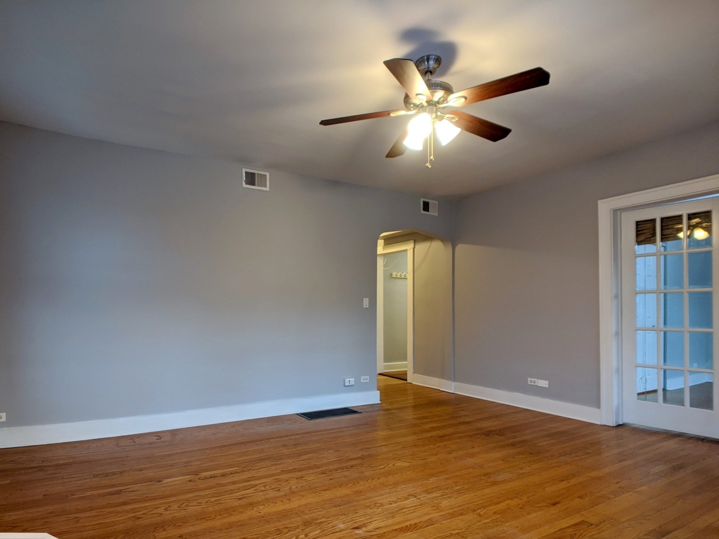 5027 North Harding Avenue, Unit 2W Chicago, IL 60625 - Photo 3 of 20 a view of an empty room with wooden floor and a ceiling fan