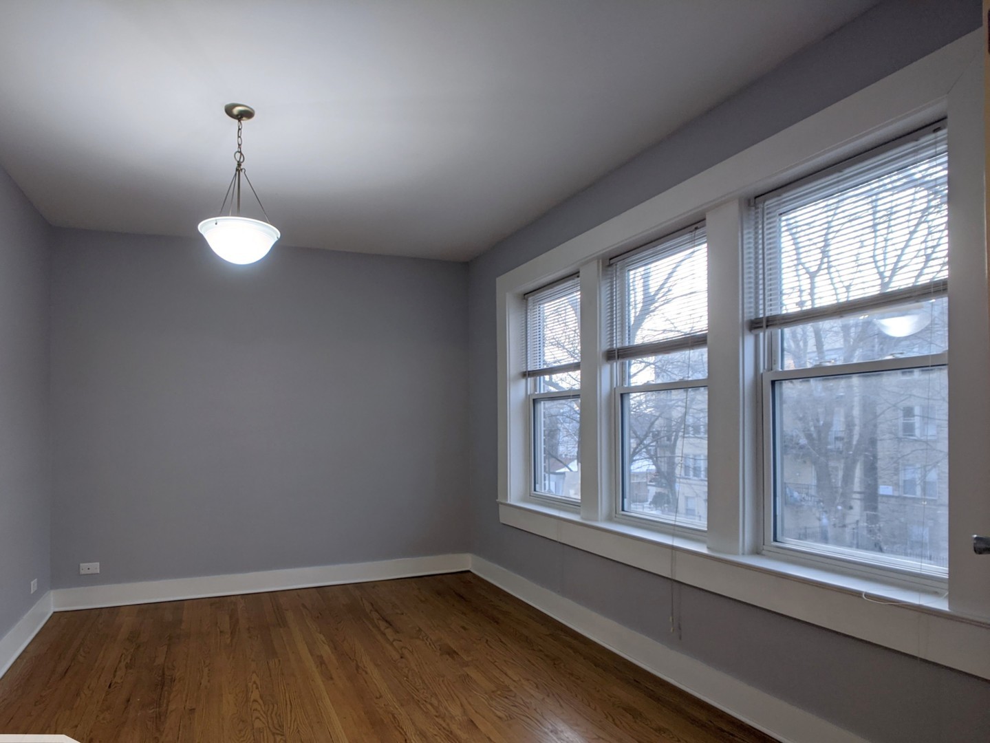 5027 North Harding Avenue, Unit 2W Chicago, IL 60625 - Photo 5 of 20 a view of an empty room with wooden floor and a window