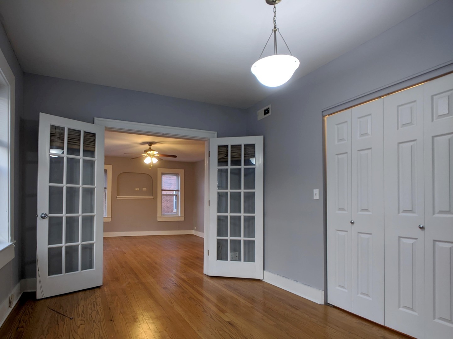 5027 North Harding Avenue, Unit 2W Chicago, IL 60625 - Photo 6 of 20 a view of empty room with windows and wooden floor