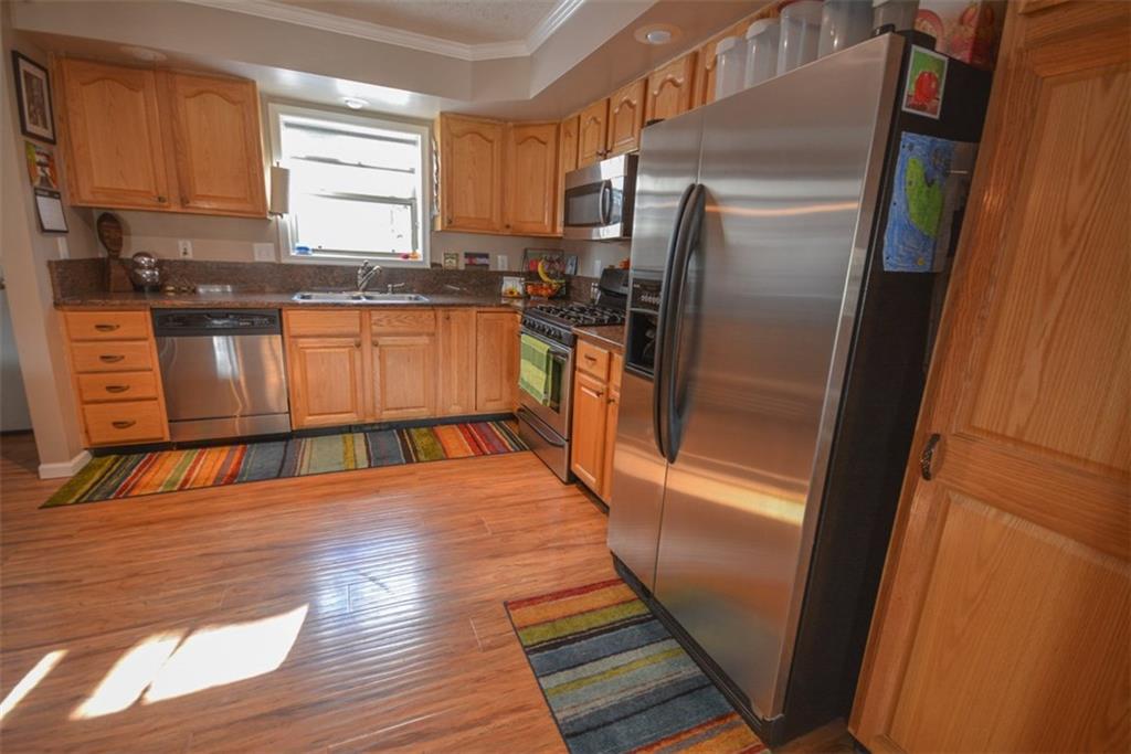 257 Huron Road, Unit E24 Breckenridge, CO 80424 - Photo 7 of 29 a kitchen with stainless steel appliances granite countertop a refrigerator a stove and a sink with wooden floor