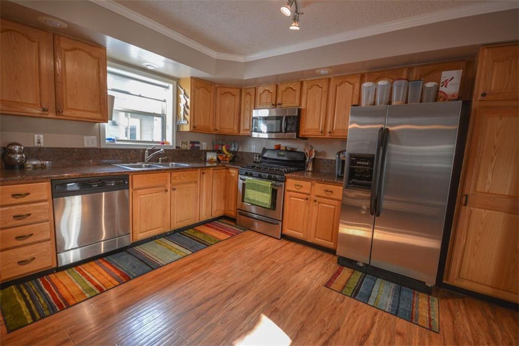 257 Huron Road, Unit E24 Breckenridge, CO 80424 - Photo 8 of 29 a kitchen with stainless steel appliances granite countertop a stove a sink dishwasher a refrigerator and white cabinets with wooden floor