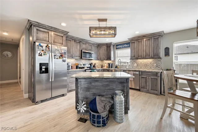 a kitchen with stainless steel appliances granite countertop a refrigerator and a stove top oven
