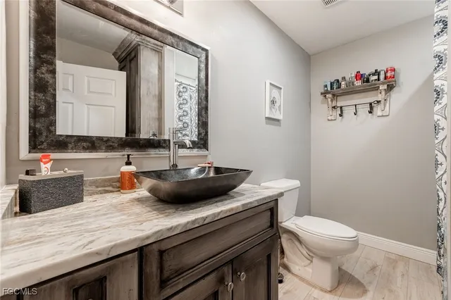a bathroom with a granite countertop sink a toilet and a mirror