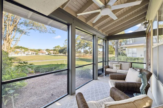 a living room with furniture and floor to ceiling windows