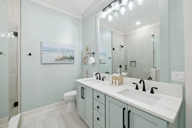 a bathroom with a double vanity sink mirror and toilet