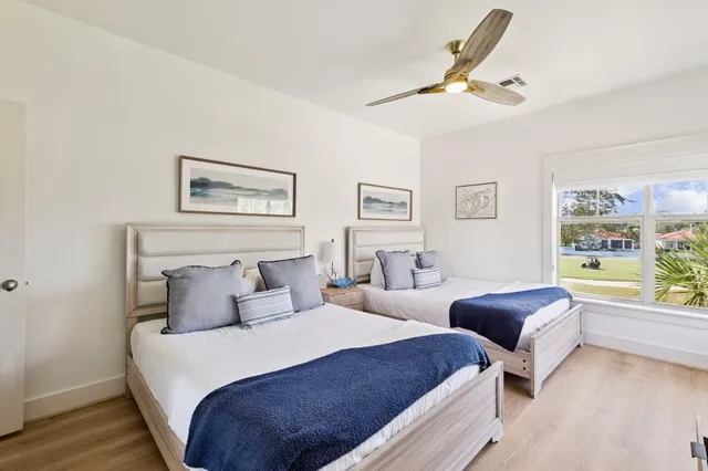 a bedroom with two beds and a large window