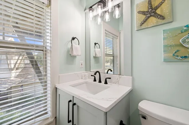 a bathroom with a sink vanity mirror and toilet