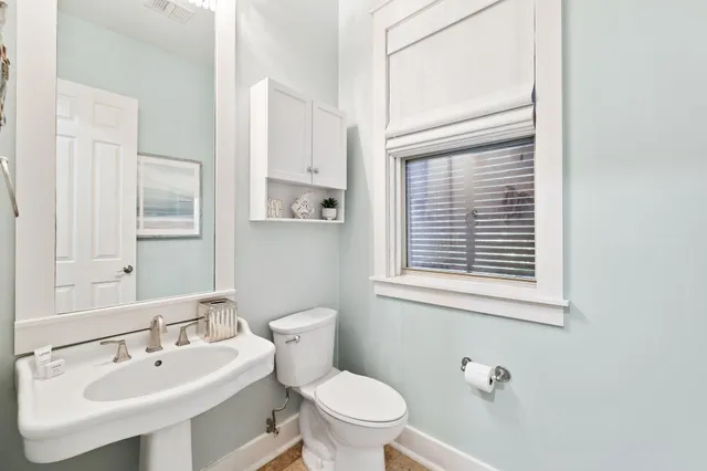 a bathroom with a toilet a sink and a mirror