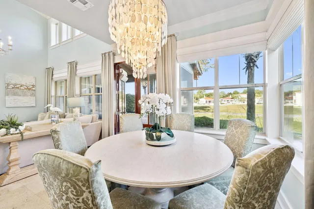 a dining room with furniture chandelier and wooden floor