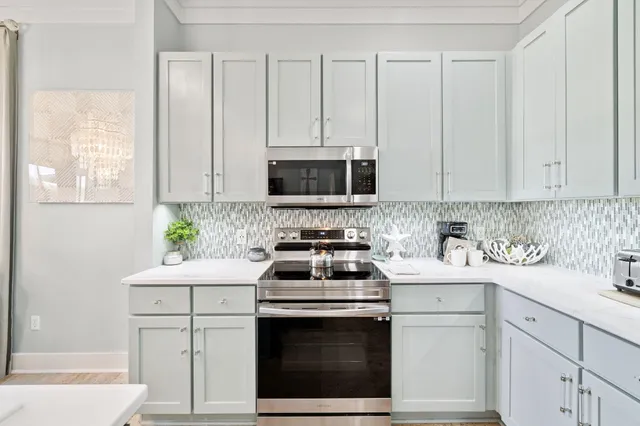 a kitchen with white cabinets stainless steel appliances and sink