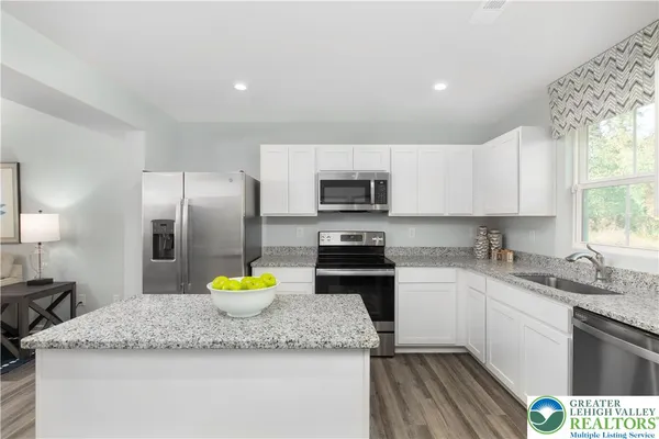 a kitchen with a sink a counter top space appliances and cabinets