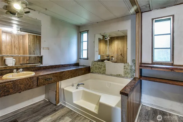 a bathroom with a tub a toilet and a shower