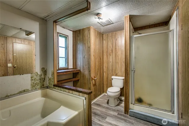 a bathroom with a granite countertop sink toilet mirror and a bathtub