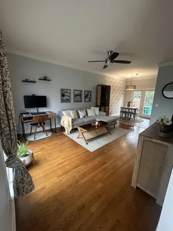 a living room with furniture hard wood floor and a flat screen tv