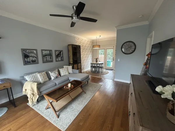 a living room with furniture and a wooden floor