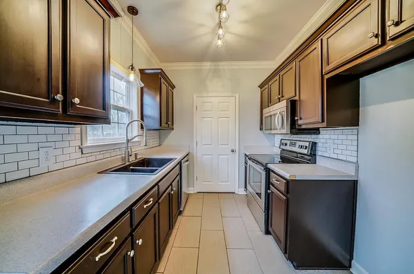 a kitchen with stainless steel appliances a sink stove and refrigerator