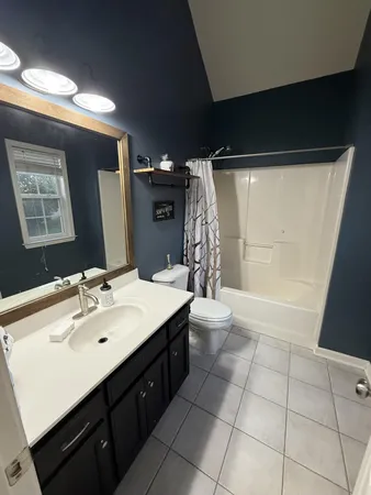 a spacious bathroom with a double vanity sink toilet and a mirror