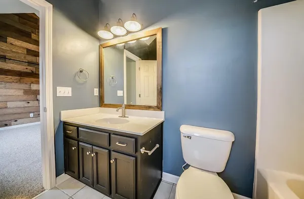 a bathroom with a toilet a sink and mirror