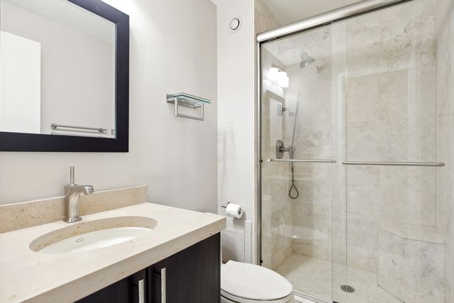 a bathroom with a sink toilet a mirror and shower