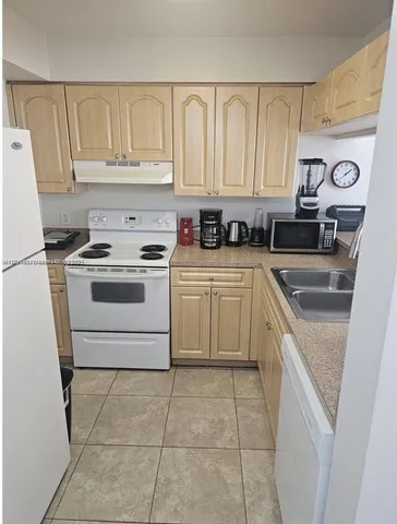 a kitchen with a stove sink and a refrigerator