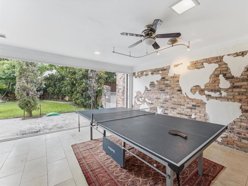 6160 Spring Valley Road Dallas, TX 75240 - Photo 22 of 40 Open-concept interior space featuring a partial exposed brick wall, track lighting, and a ceiling fan
