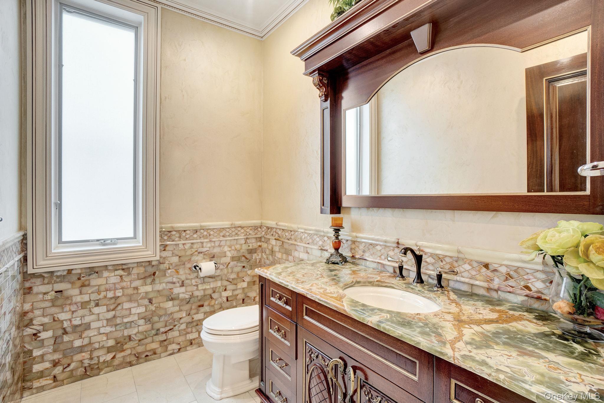 181-30 Tudor Road Queens, NY 11432 - Photo 14 of 46 Bathroom with vanity, tile walls, light tile patterned floors, a wainscoted wall, and ornamental molding