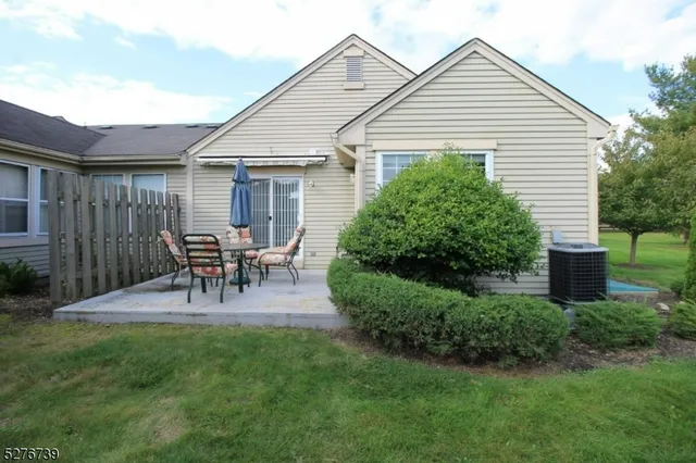 a view of a chair and table in backyard of the house