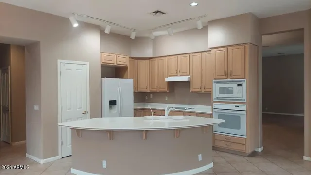 a view of kitchen with refrigerator stove microwave and cabinets