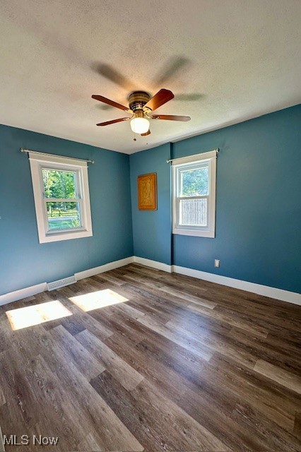 4184 Johnson Road Barberton, OH 44203 - Photo 12 of 25 Unfurnished room with dark wood-style flooring, a textured ceiling, and ceiling fan
