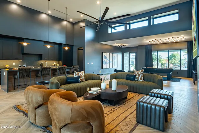 a living room with furniture kitchen view and a large window