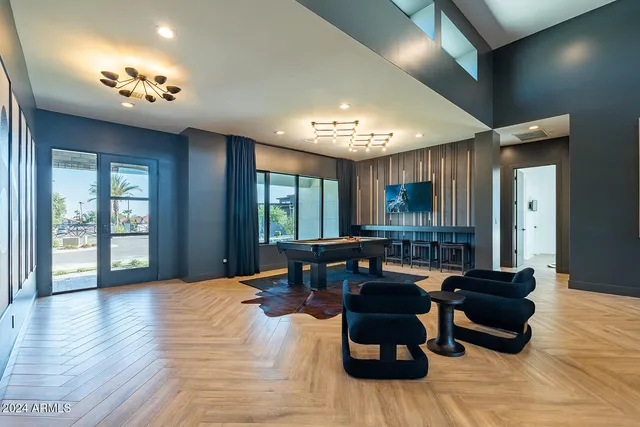 a living room with furniture a flat screen tv and a floor to ceiling window