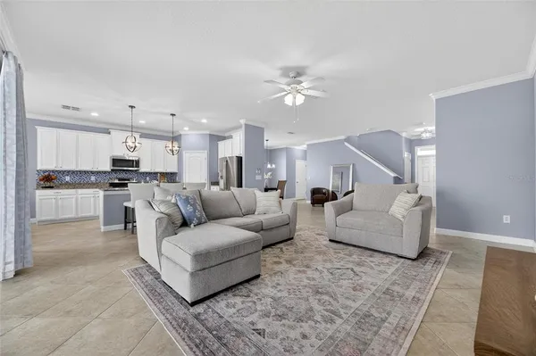 a living room with furniture and a ceiling fan