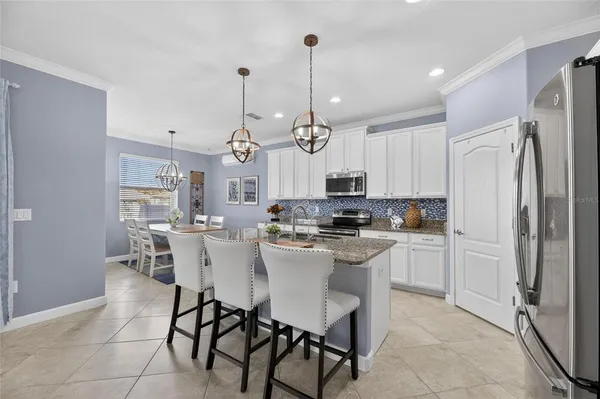 a kitchen with stainless steel appliances granite countertop a stove a sink a microwave a refrigerator and cabinets