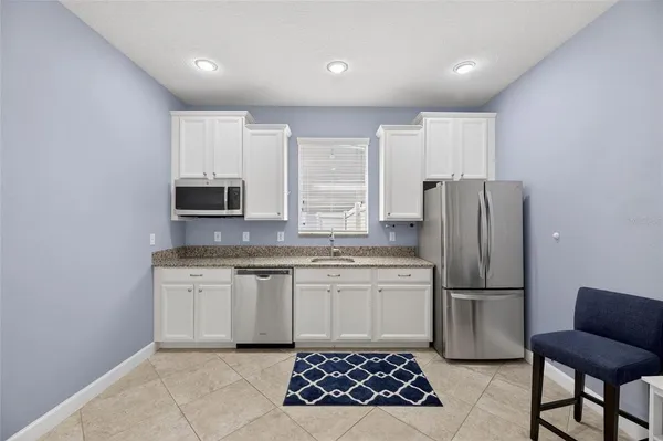 a view of an empty room with a window and a dresser