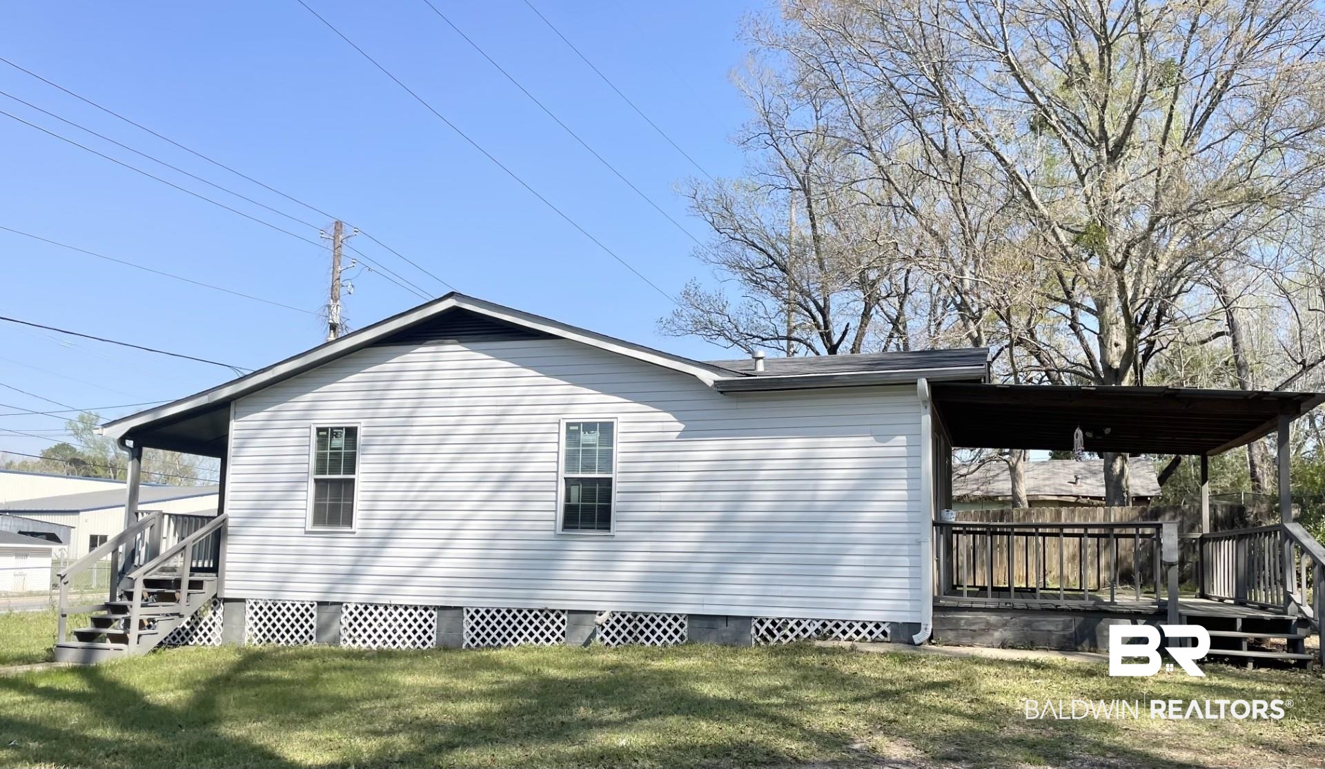 85 Cody Road South Mobile, AL 36608 - Photo 2 of 15 View of home's exterior with a lawn and fence