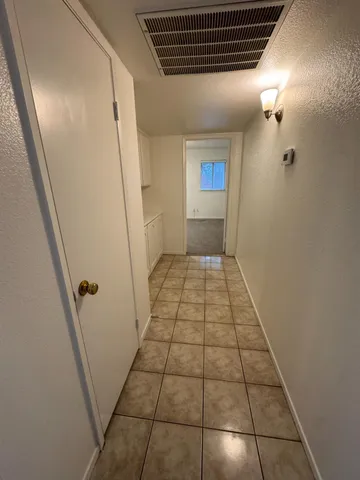 an empty room with windows and fan