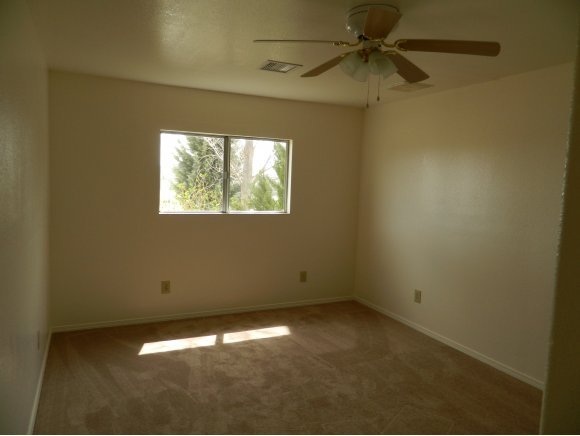 1550 Ranch House Road Paulden, AZ 86334 - Photo 15 of 24 an empty room with a window and a fan