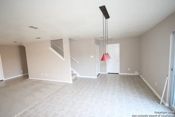 a view of an empty room with wooden floor and entryway