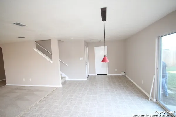 a view of an empty room with cabinet and a chandelier