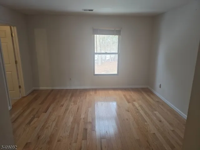 an empty room with wooden floor and closet