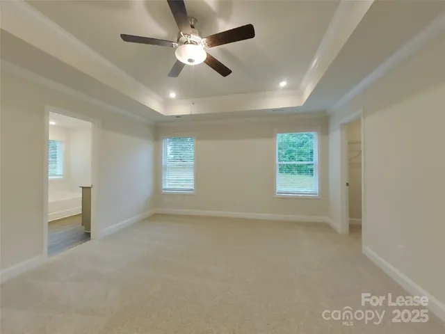en empty room with windows and ceiling fan