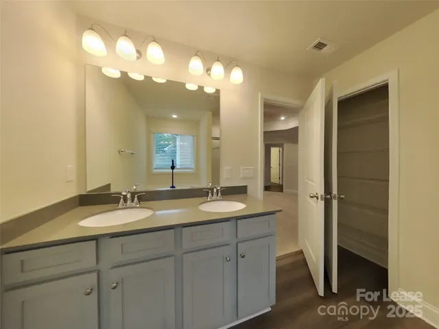 a bathroom with a granite countertop sink a large mirror and a shower