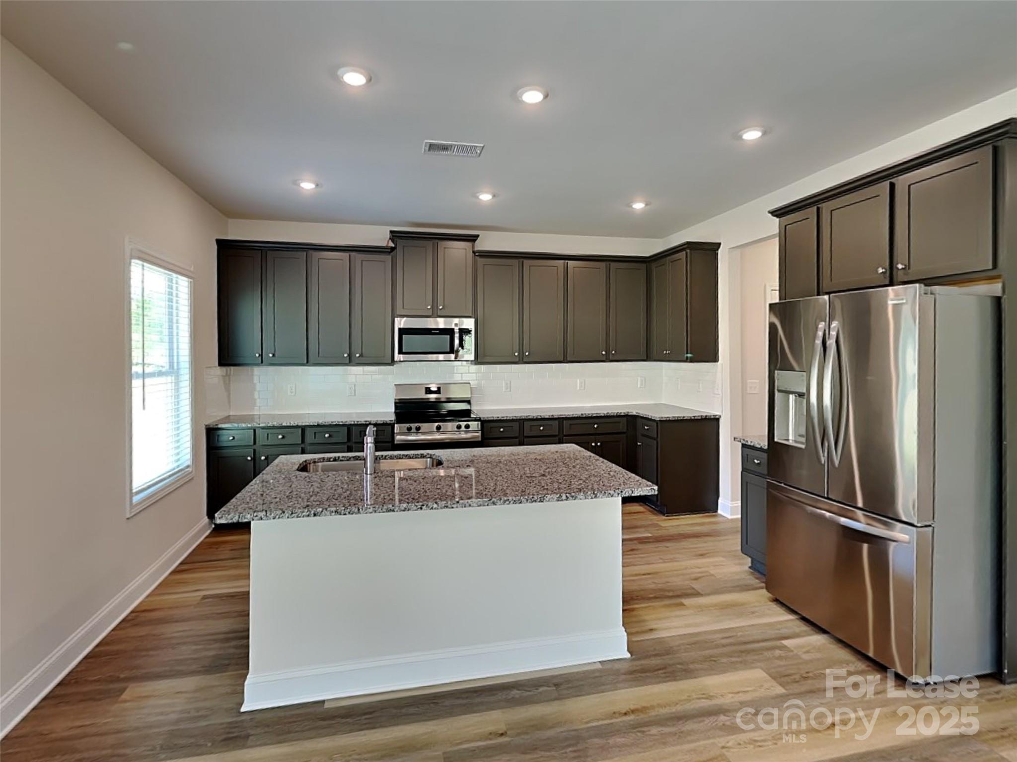 139 Queenshall Road Mooresville, NC 28117 - Photo 10 of 24 a kitchen with stainless steel appliances granite countertop a refrigerator a sink a stove a microwave and island