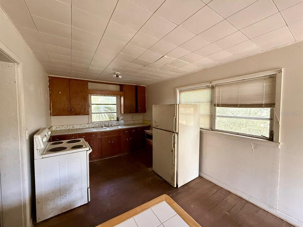 10010 Fort King Road Dade City, FL 33525 - Photo 5 of 36 a kitchen with a refrigerator and a stove top oven