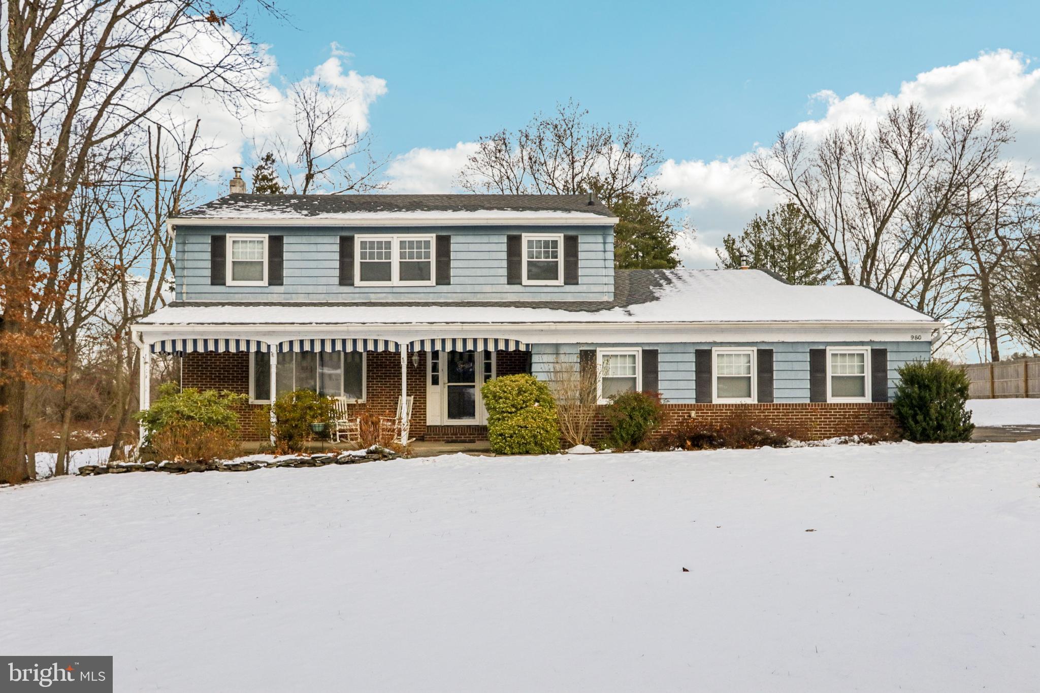 a front view of a house with a yard covered with snow