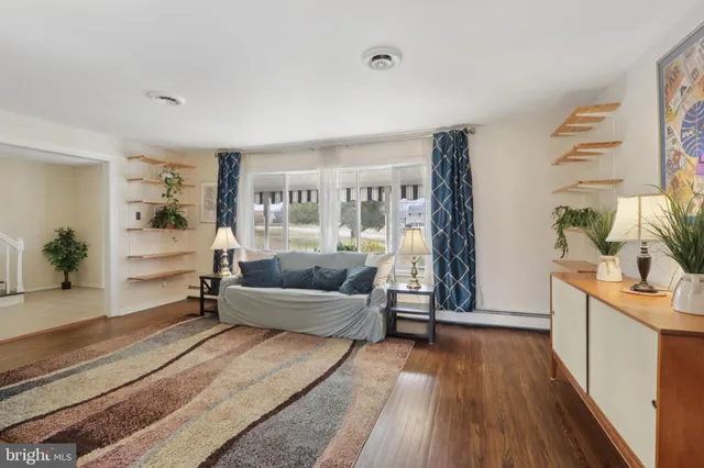 a dining room with wooden floor a chandelier a wooden table and chairs