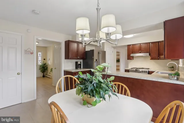 a living room with stainless steel appliances granite countertop furniture a kitchen island a stove a refrigerator with a dining table and chairs